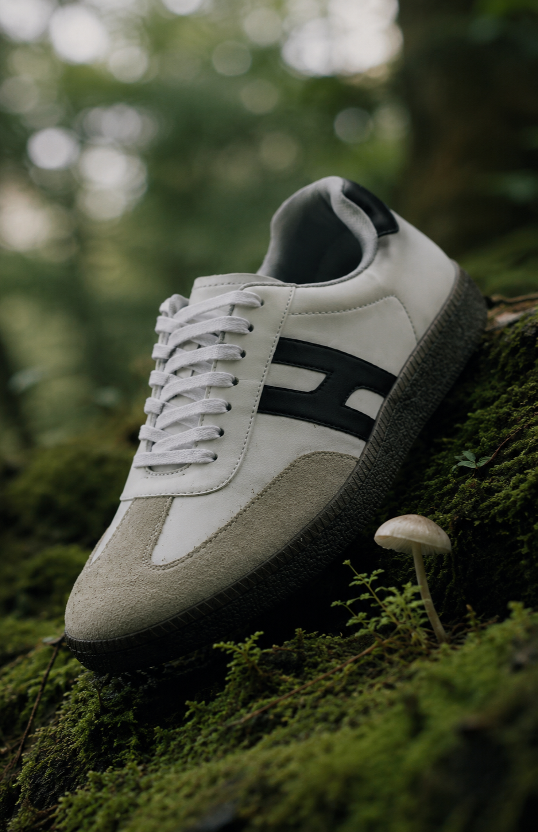 White and black sneaker on a mossy surface with blurred green background